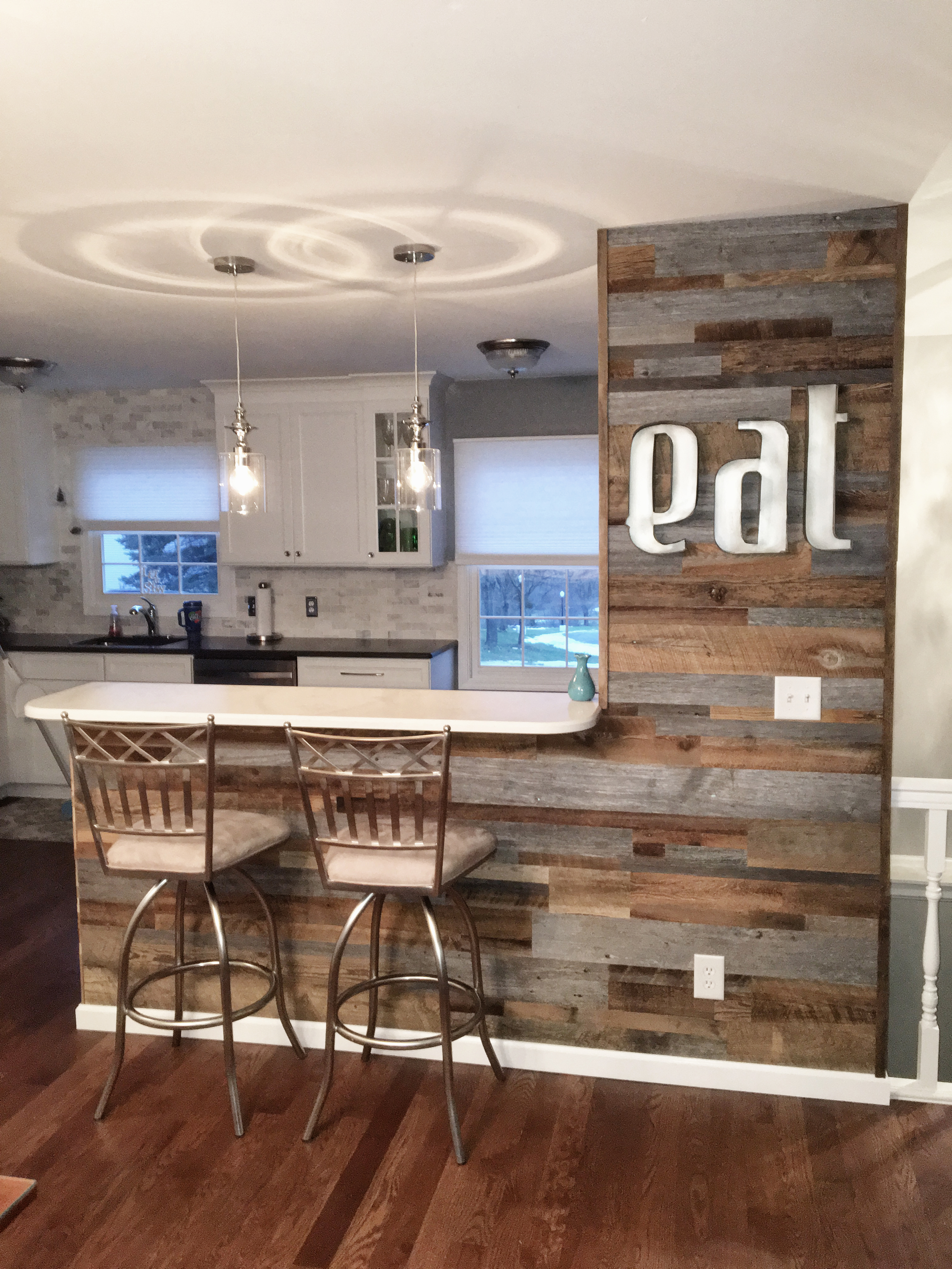 Customer kitchen with reclaimed barn wood accent wall and bar area with EAT sign