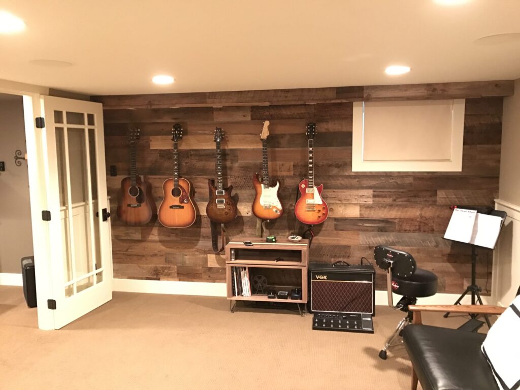 Basement music room with a brown reclaimed wood wall and guitars