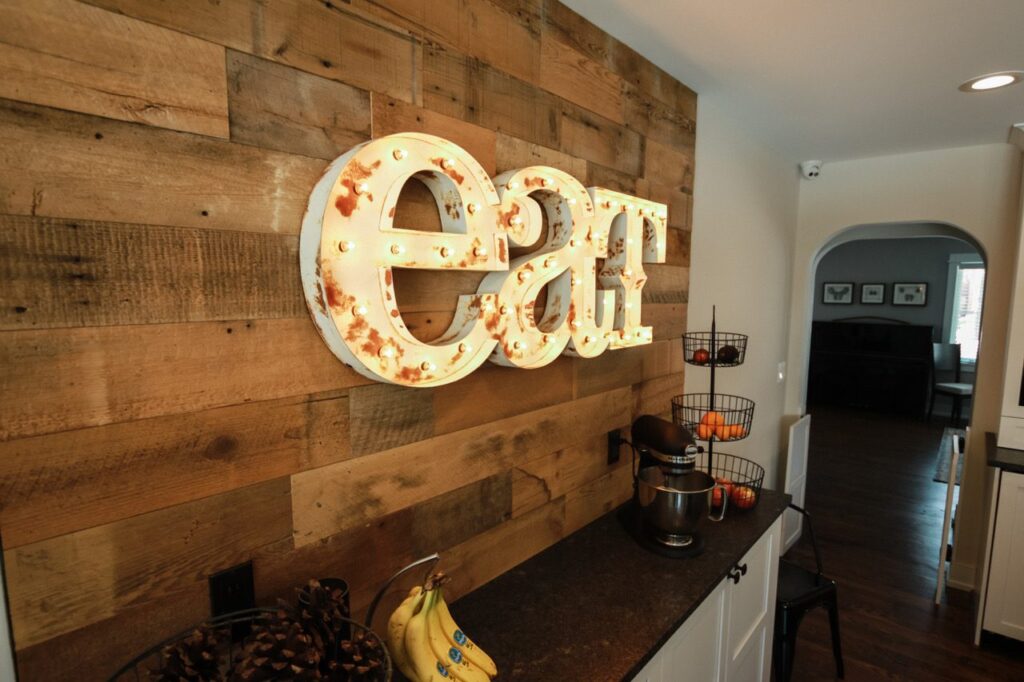 Kitchen wall of brown reclaimed barn wood planks above a counter