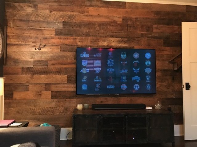 Living room TV wall covered in brown reclaimed barn wood planks