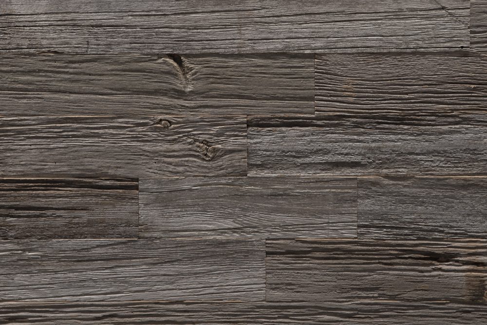 Close-up of weathered reclaimed wood with old empty nail holes and deep grain